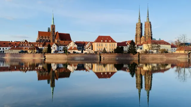 Ostrów Tumski in Wrocław with the cathedral and churches reflected in the calm Oder River
