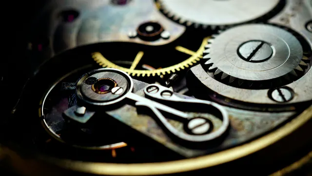 Zbliżenie na mechanizm zegarka: precyzyjne koła zębate i kamienie łożyskowe na ciemnym tle