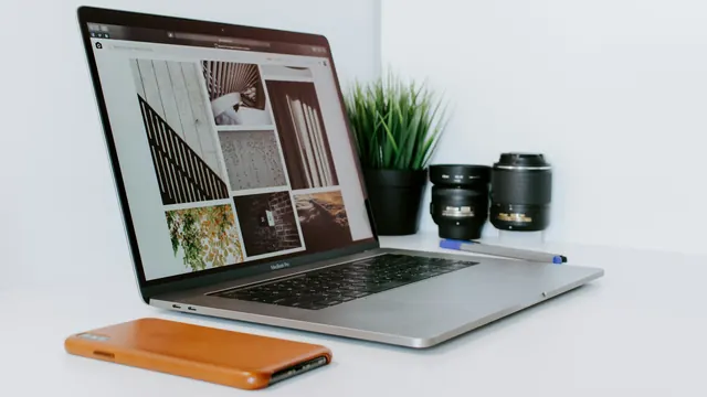 Otwarty laptop z galerią zdjęć na ekranie, obok roślina, obiektywy i telefon na białym biurku